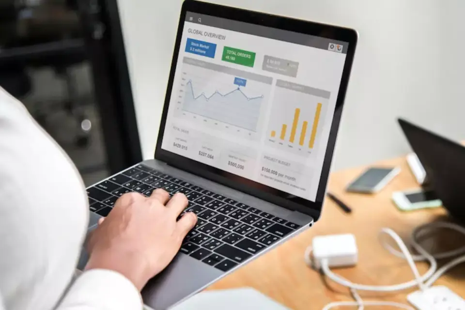 Seseorang membuka laptop melihat statistik