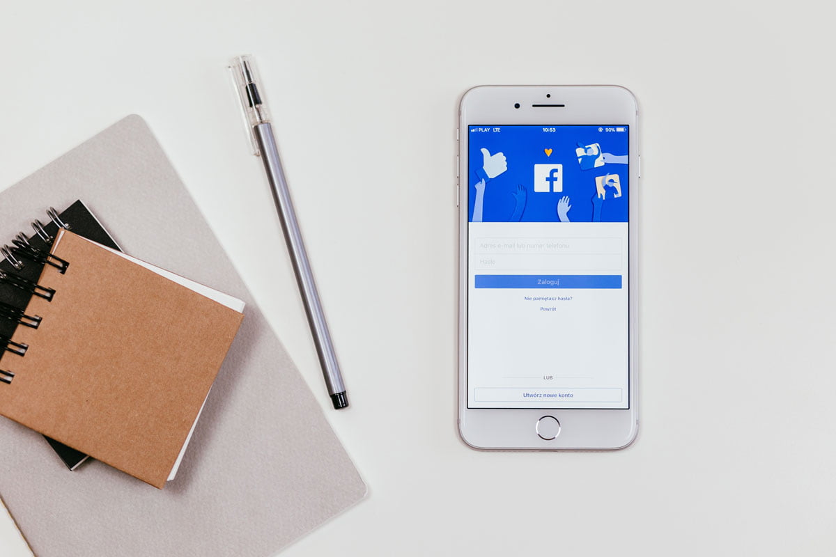 terdapat buku dan smartphone yang menampilkan facebook ads