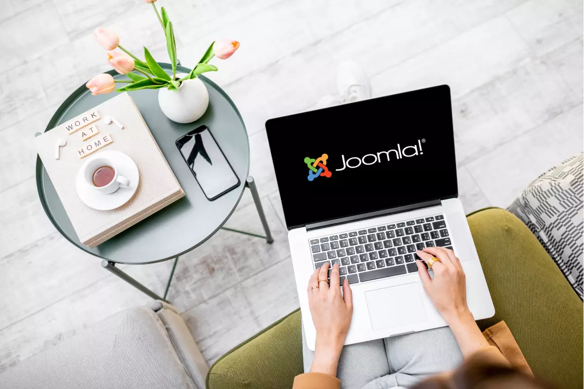 orang sedang bekerja dengan joomla melalui laptop sambil duduk